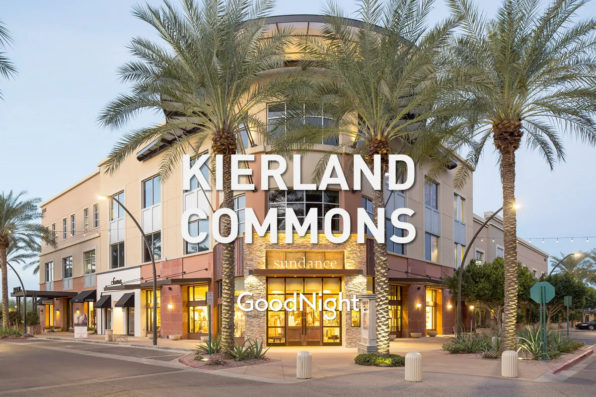 A vibrant exterior view of a Scottsdale shopping district, with palm trees lining the walkway and inviting storefronts. The scene captures the lively, social energy of the nearby attractions.